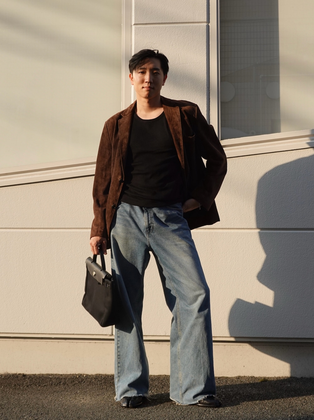 ブラック系のブーツ、ブラック系のタンクトップ、ブラウン系のテーラードジャケットを着用したメンズの秋コーディネートの1枚目の写真