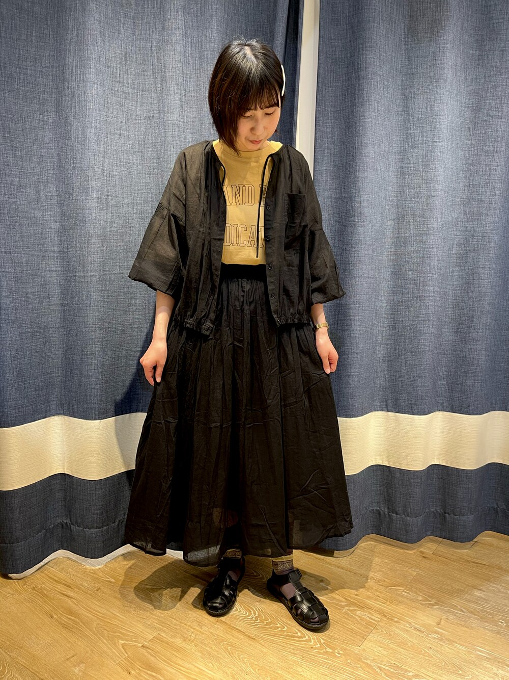 オレンジ系のTシャツ/カットソー、ブラック系のシャツ/ブラウス、ブラック系のスカートを着用したレディースの春コーディネートの1枚目の写真