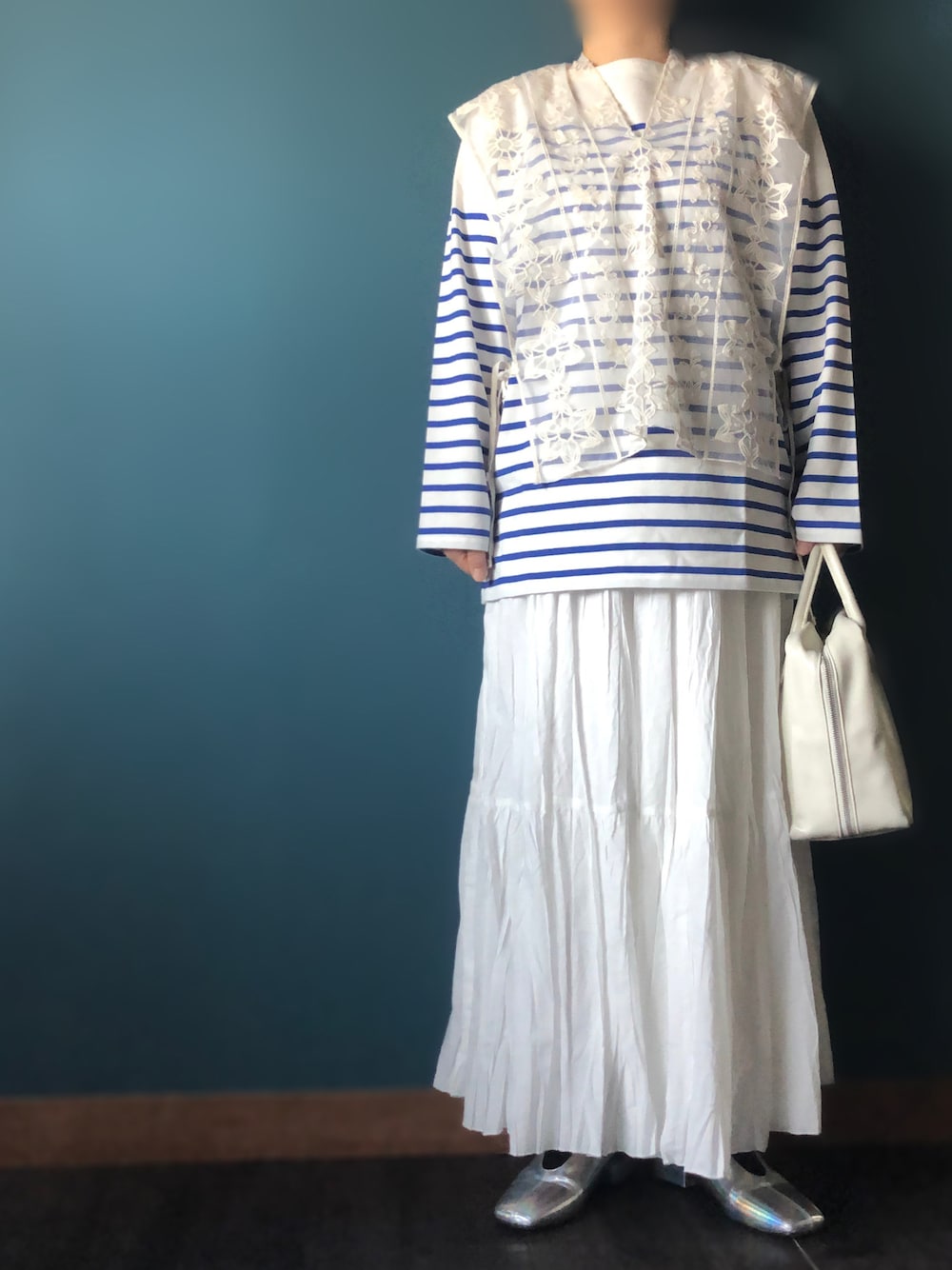 ホワイト系のボストンバッグ、シルバー系のパンプス、ホワイト系のスカートを着用したレディースの春コーディネートの1枚目の写真