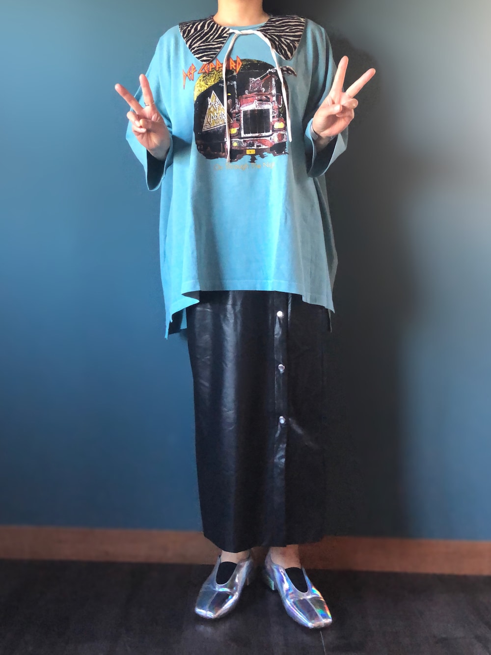 ブルー系のTシャツ/カットソー、ブラック系のスカート、シルバー系のパンプスを着用したレディースの秋コーディネートの1枚目の写真