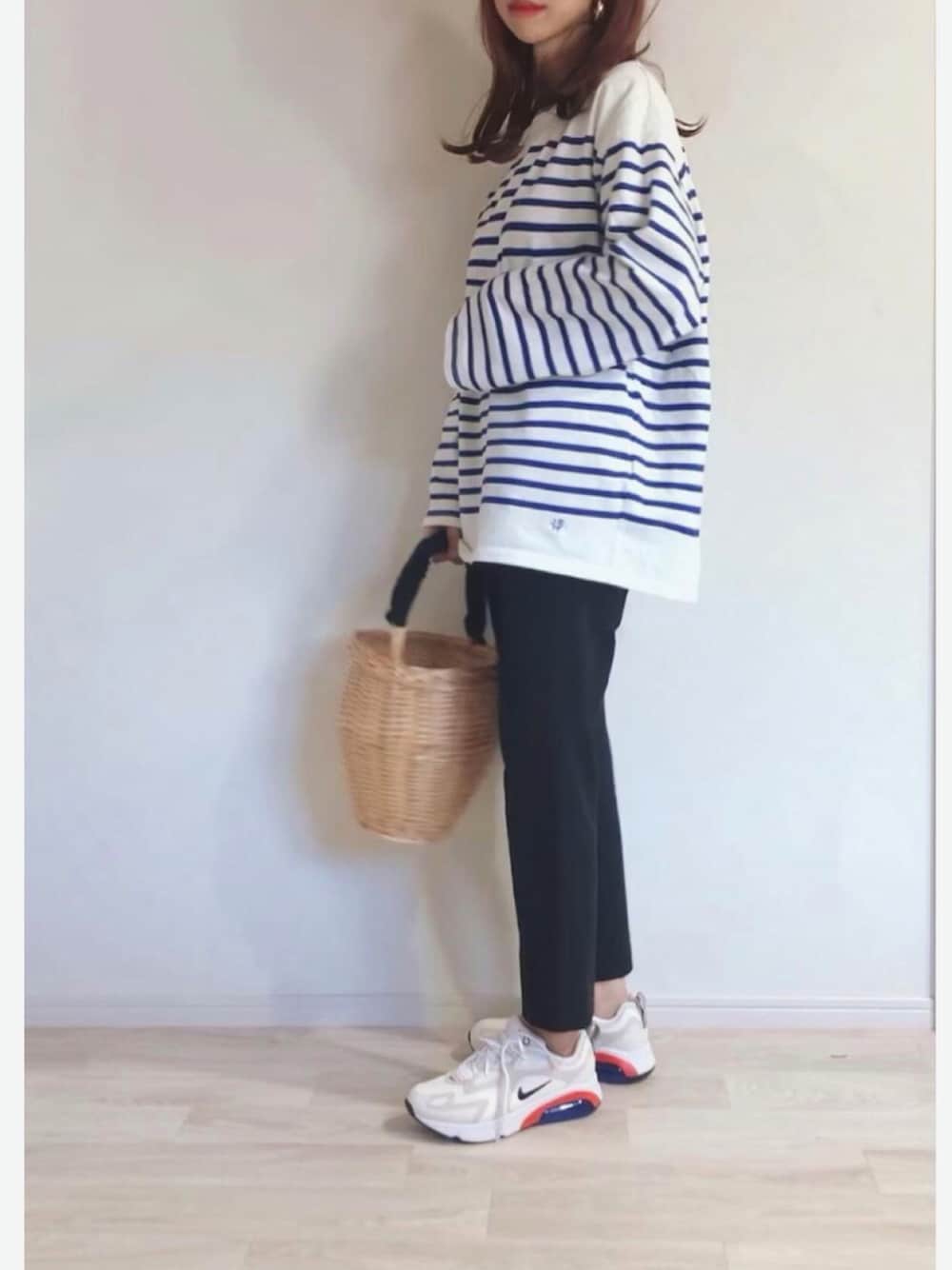 ブルー系のTシャツ/カットソー、ブラック系のスラックス、ベージュ系のスニーカーを着用したレディースの秋コーディネートの1枚目の写真