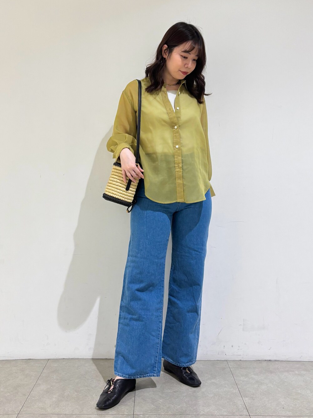 グレー系のタンクトップ、イエロー系のシャツ/ブラウス、ブルー系のデニムパンツを着用したレディースの春コーディネートの1枚目の写真