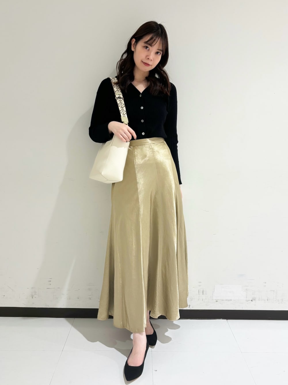 ベージュ系のショルダーバッグ、ホワイト系のトートバッグ、ブラック系のパンプスを着用したレディースの冬コーディネートの1枚目の写真