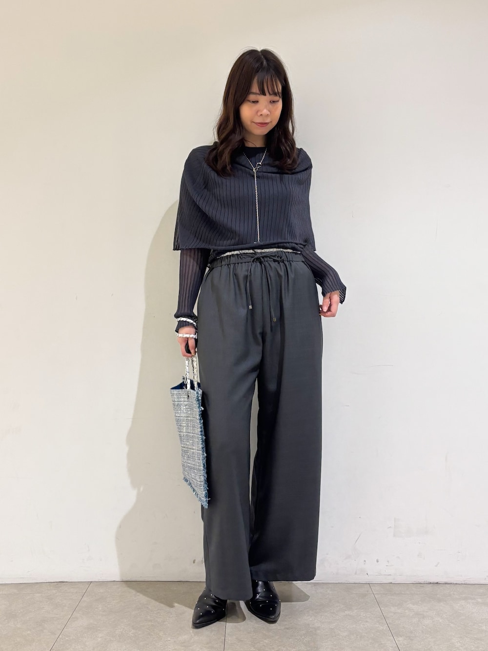 グレー系のニット/セーター、グレー系のその他パンツ、シルバー系のトートバッグを着用したレディースの秋コーディネートの1枚目の写真