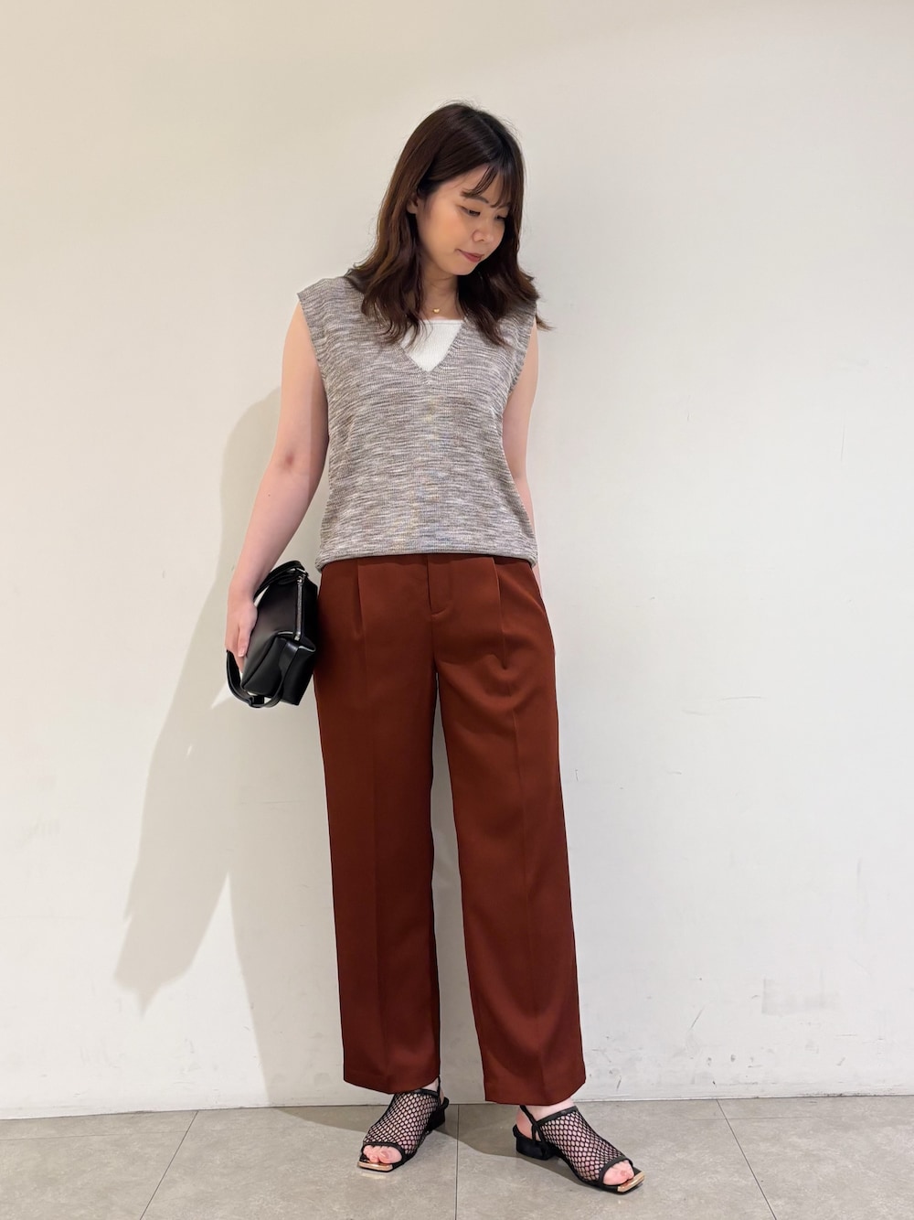 ピンク系のベスト、ブラウン系のその他パンツ、ブラック系のサンダルを着用したレディースの秋コーディネートの1枚目の写真