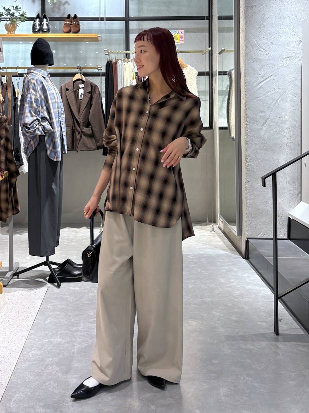 ベージュ系のその他パンツ、ブラウン系のシャツ/ブラウス、ブラック系のボストンバッグを着用したレディースの秋コーディネートの1枚目の写真