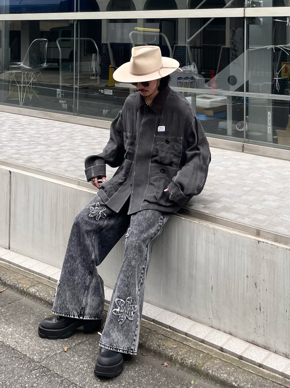 ブラック系のデニムパンツを着用したメンズの春コーディネートの1枚目の写真