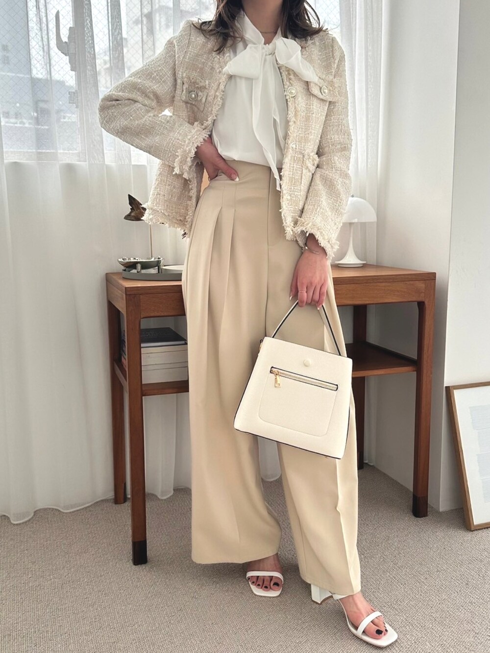 ホワイト系のシャツ/ブラウス、ベージュ系のテーラードジャケット、ホワイト系のハンドバッグを着用したレディースの春コーディネートの1枚目の写真