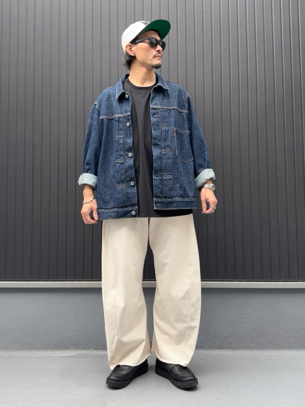 ブラック系のTシャツ/カットソー、ブルー系のデニムジャケット、ホワイト系のスウェットパンツを着用したメンズの秋コーディネートの1枚目の写真