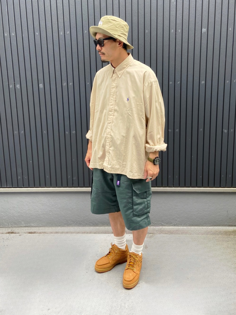 ベージュ系のシャツ/ブラウス、グリーン系のパンツ、イエロー系のブーツを着用したメンズの夏コーディネートの1枚目の写真