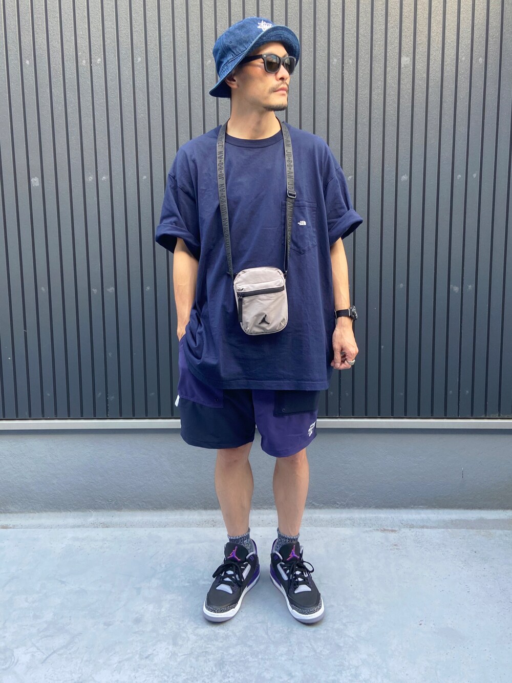 グレー系のバッグ、ブルー系のTシャツ/カットソー、ブルー系のパンツを着用したメンズの秋コーディネートの1枚目の写真