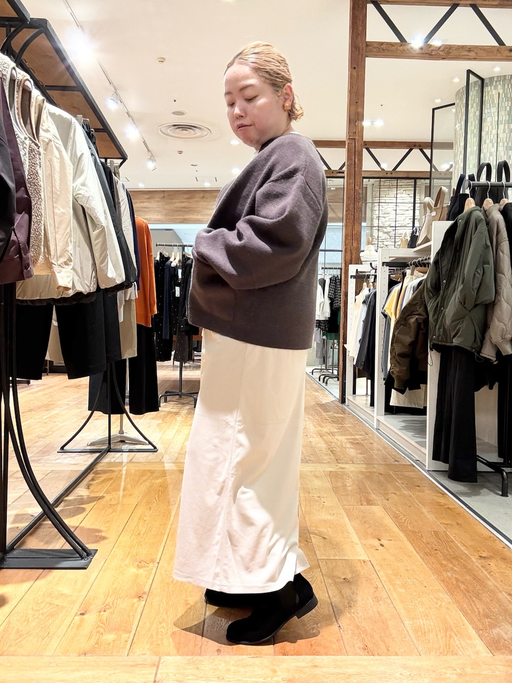 ブラウン系のブルゾン、ホワイト系のTシャツ/カットソー、ホワイト系のスカートを着用したレディースの秋コーディネートの1枚目の写真