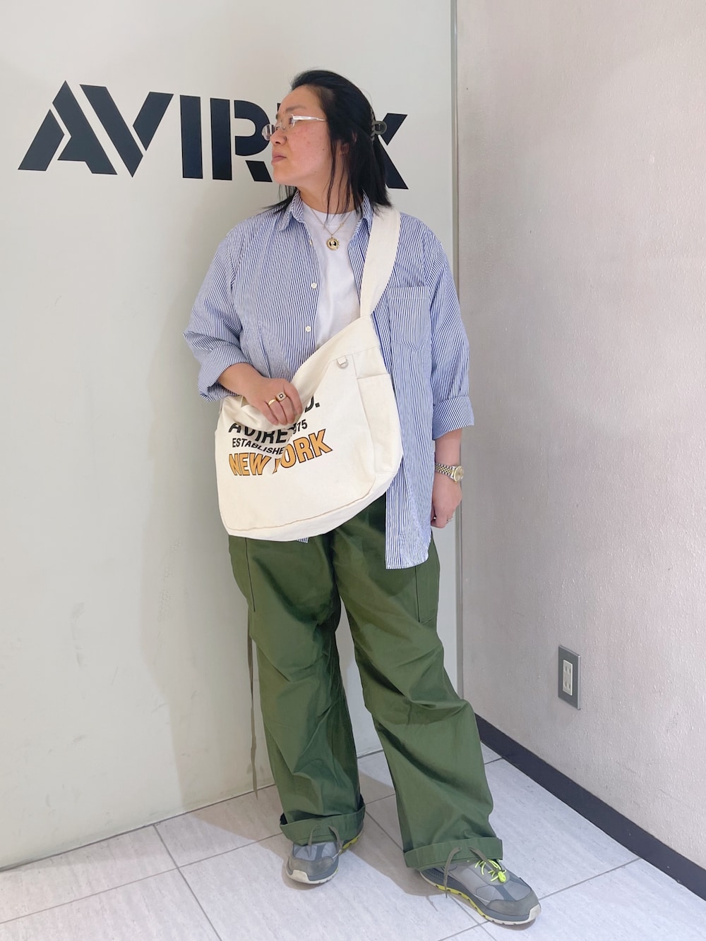 グリーン系のカーゴパンツ、ブルー系のシャツ/ブラウス、ホワイト系のショルダーバッグを着用したレディースの春コーディネートの1枚目の写真