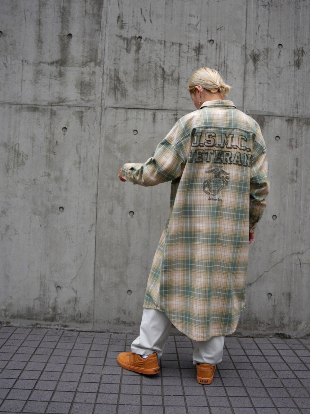 ベージュ系のシャツワンピース、ゴールド系のスニーカー、ホワイト系のデニムパンツを着用したレディースの秋コーディネートの1枚目の写真