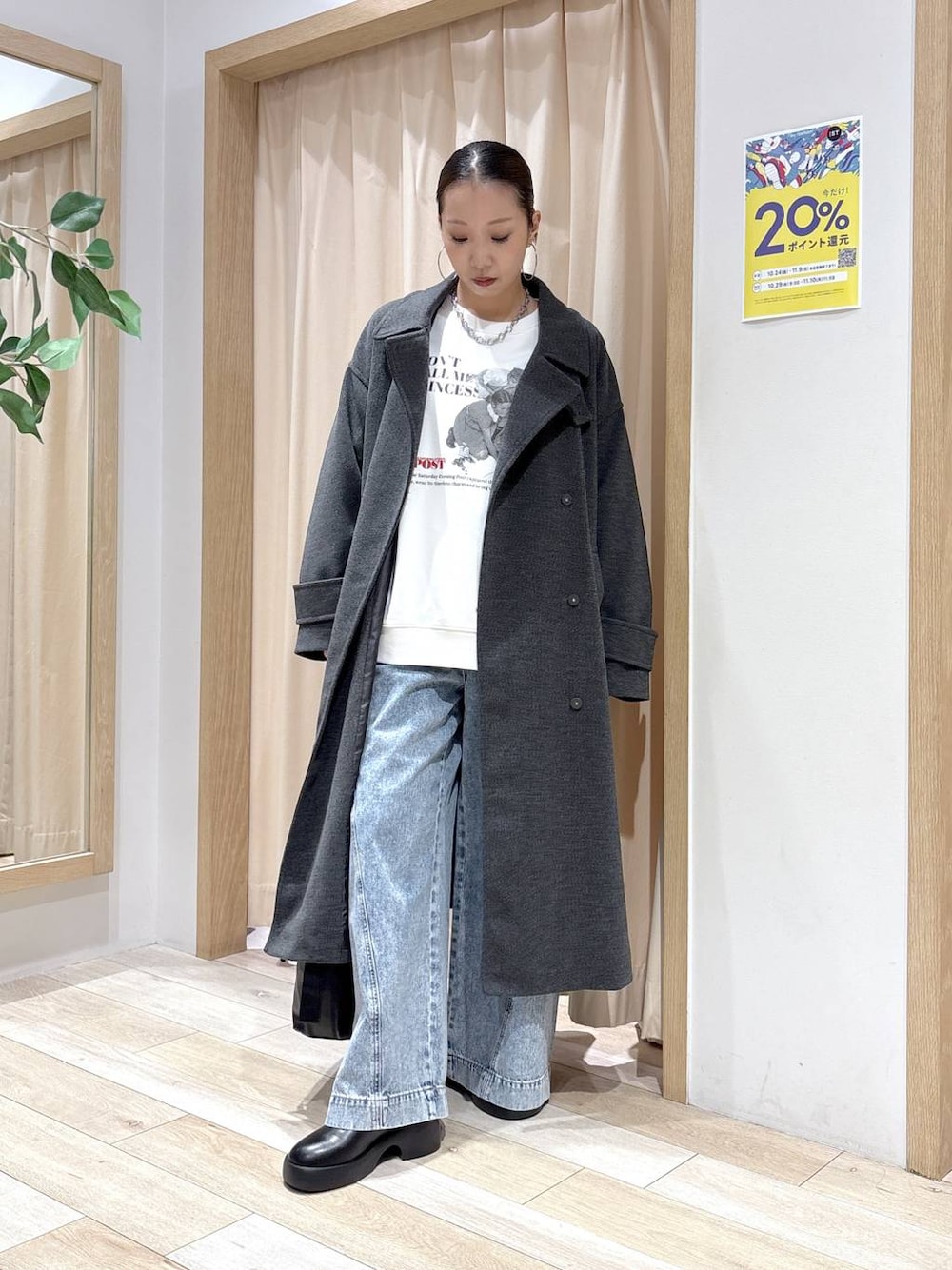 ブルー系のデニムパンツ、グレー系のステンカラーコート、ブラック系のショルダーバッグを着用したレディースの秋コーディネートの1枚目の写真