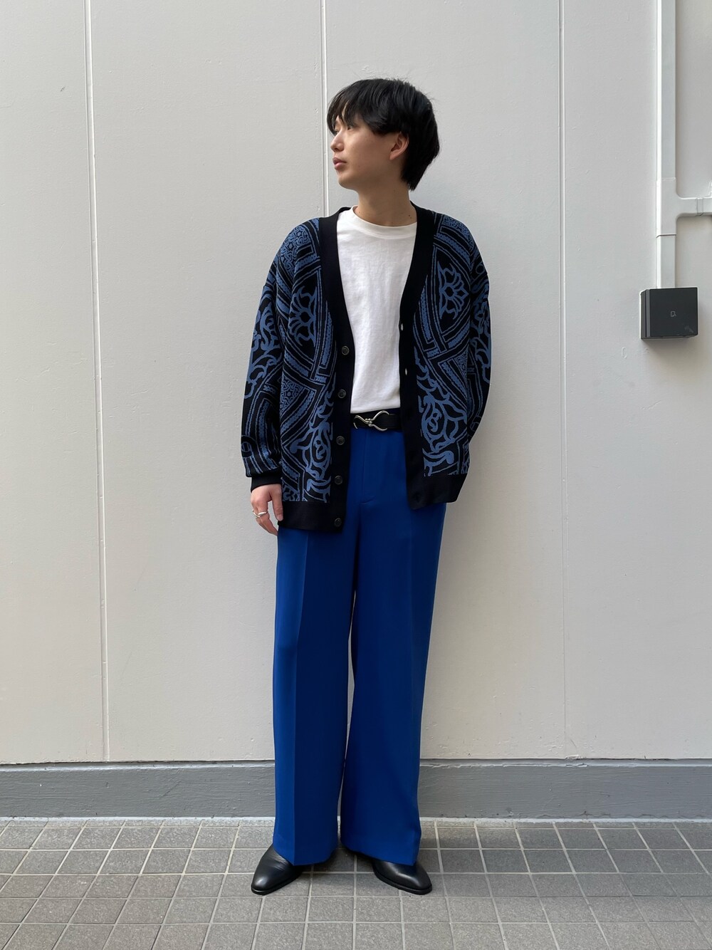 ブラック系のカーディガン/ボレロ、ブラック系のドレスシューズ、ブルー系のスラックスを着用したメンズの春コーディネートの4枚目の写真