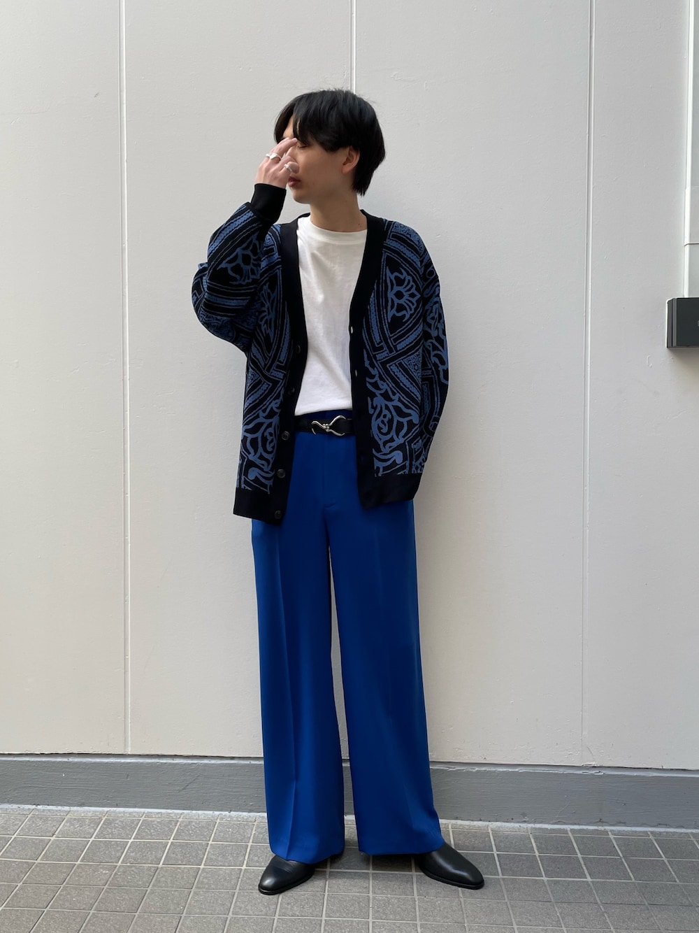 ブラック系のカーディガン/ボレロ、ブラック系のドレスシューズ、ブルー系のスラックスを着用したメンズの春コーディネートの3枚目の写真