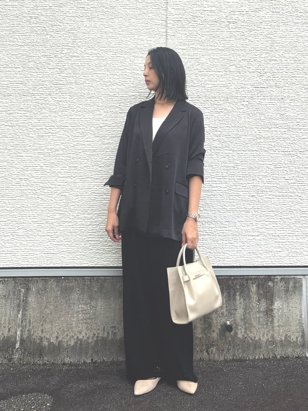 ブラック系のその他アウター、ブラック系のその他パンツ、グレー系のハンドバッグを着用したレディースの秋コーディネートの1枚目の写真