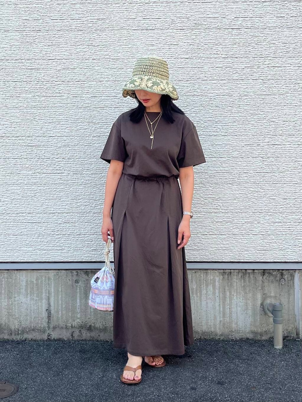 ホワイト系のショルダーバッグ、ブラウン系のワンピース、ホワイト系のハットを着用したレディースの夏コーディネートの1枚目の写真