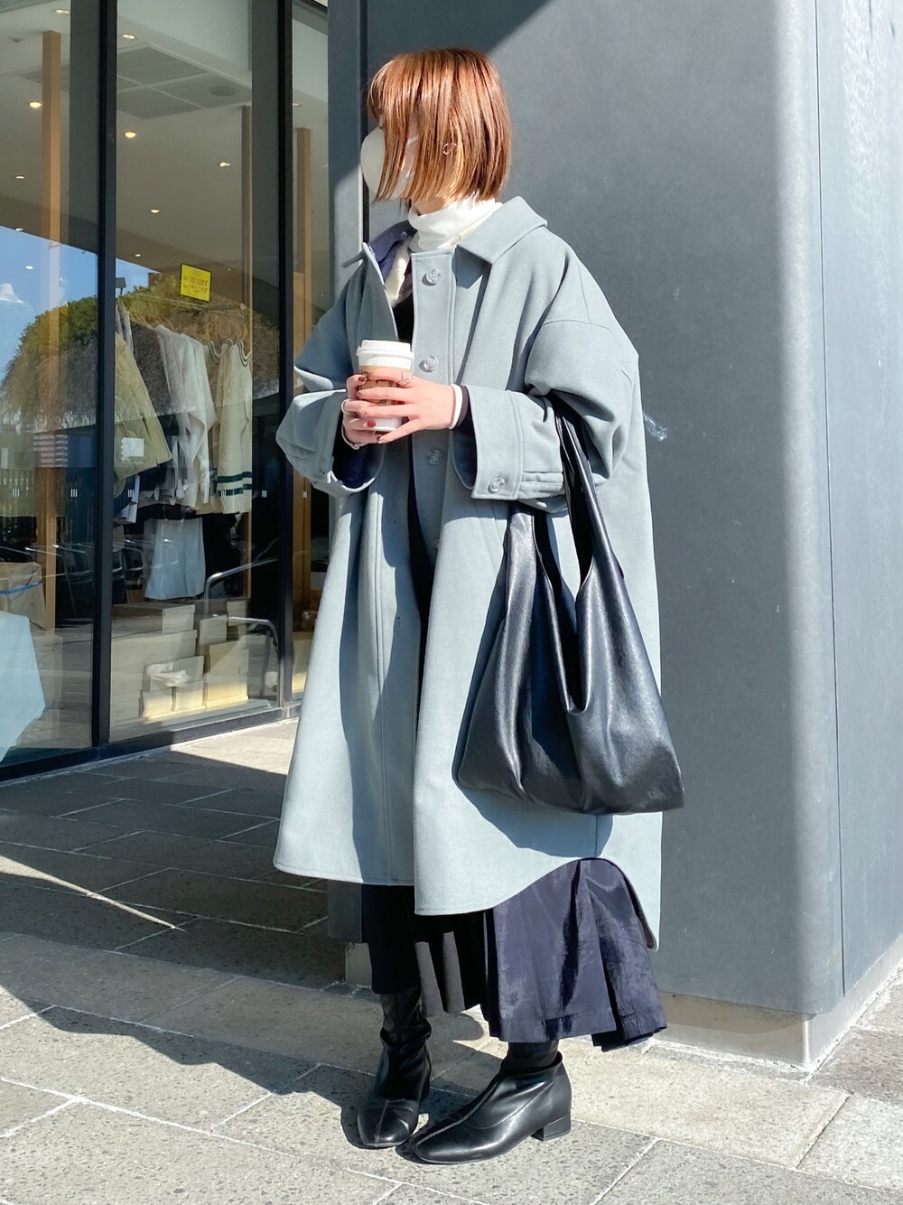 グレー系のダウンジャケット/コート、ブラック系のトートバッグ、ブラック系のブーツを着用したレディースの冬コーディネートの1枚目の写真