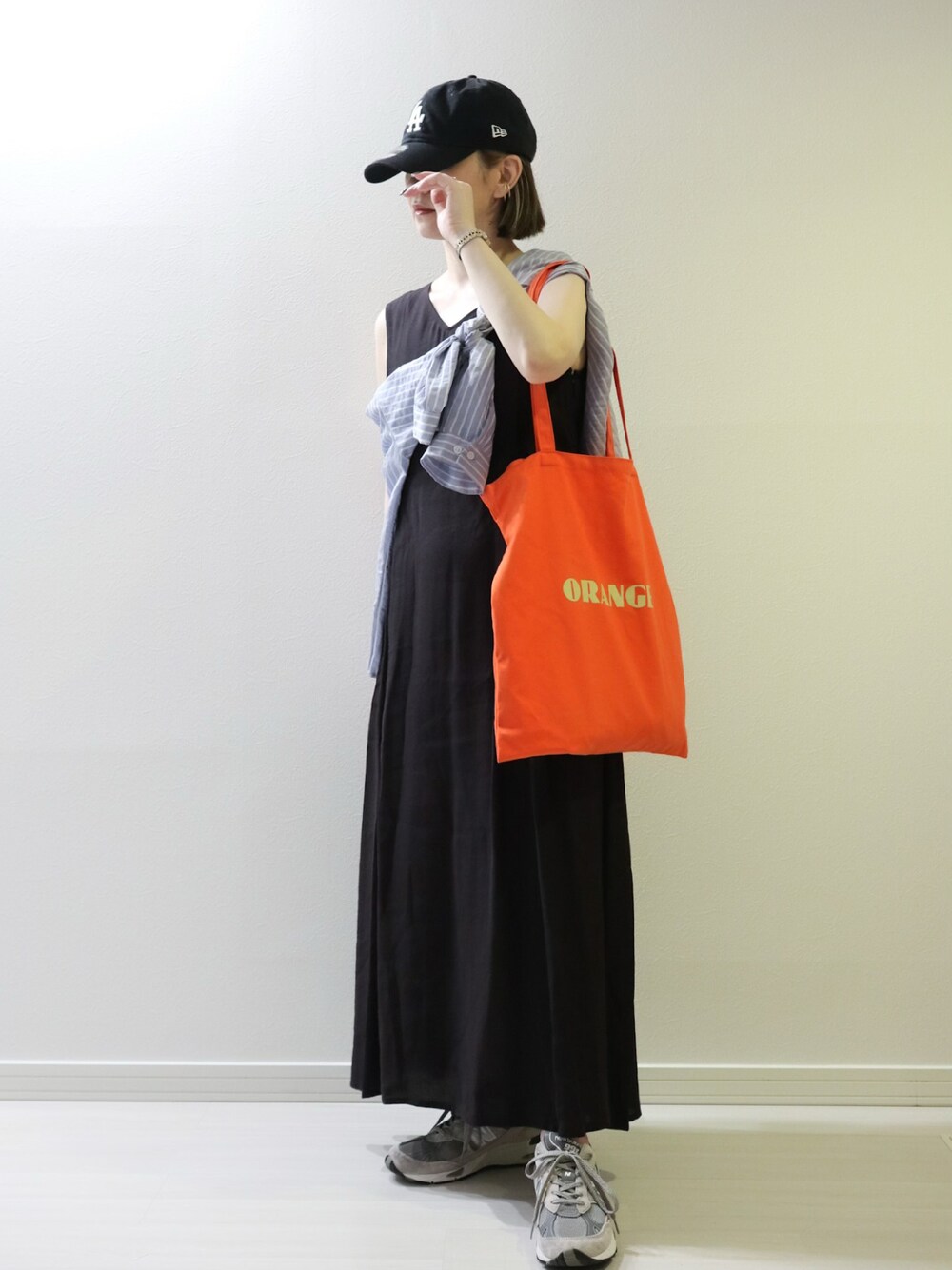 ブラック系のワンピース、ブルー系のシャツ/ブラウス、オレンジ系のトートバッグを着用したレディースの夏コーディネートの1枚目の写真
