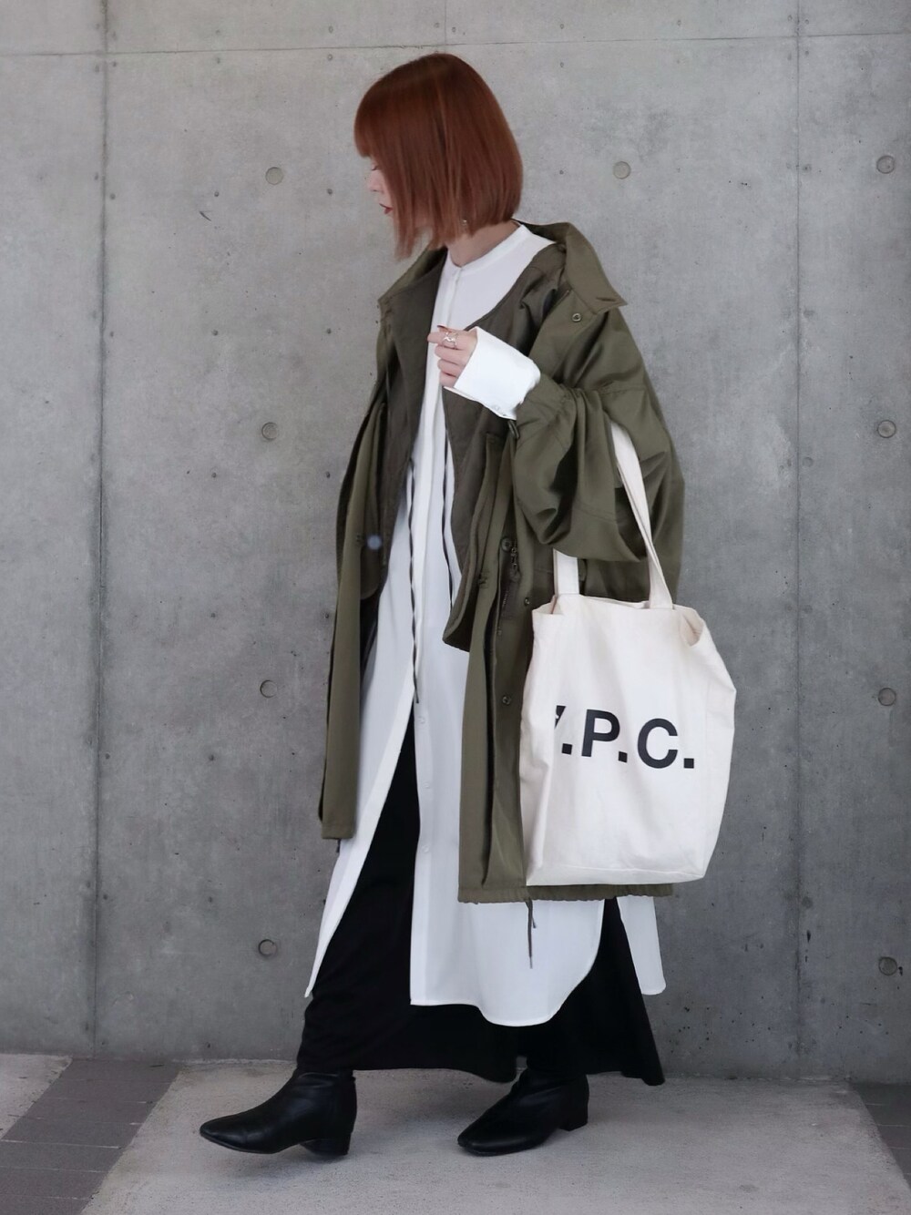 グリーン系のモッズコート、グリーン系のベスト、ブラック系のワンピースを着用したレディースの秋コーディネートの1枚目の写真