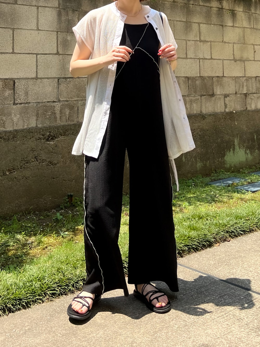 ブラック系のサロペット/オーバーオール、ホワイト系のシャツ/ブラウス、ブラック系のサンダルを着用したレディースの夏コーディネートの1枚目の写真