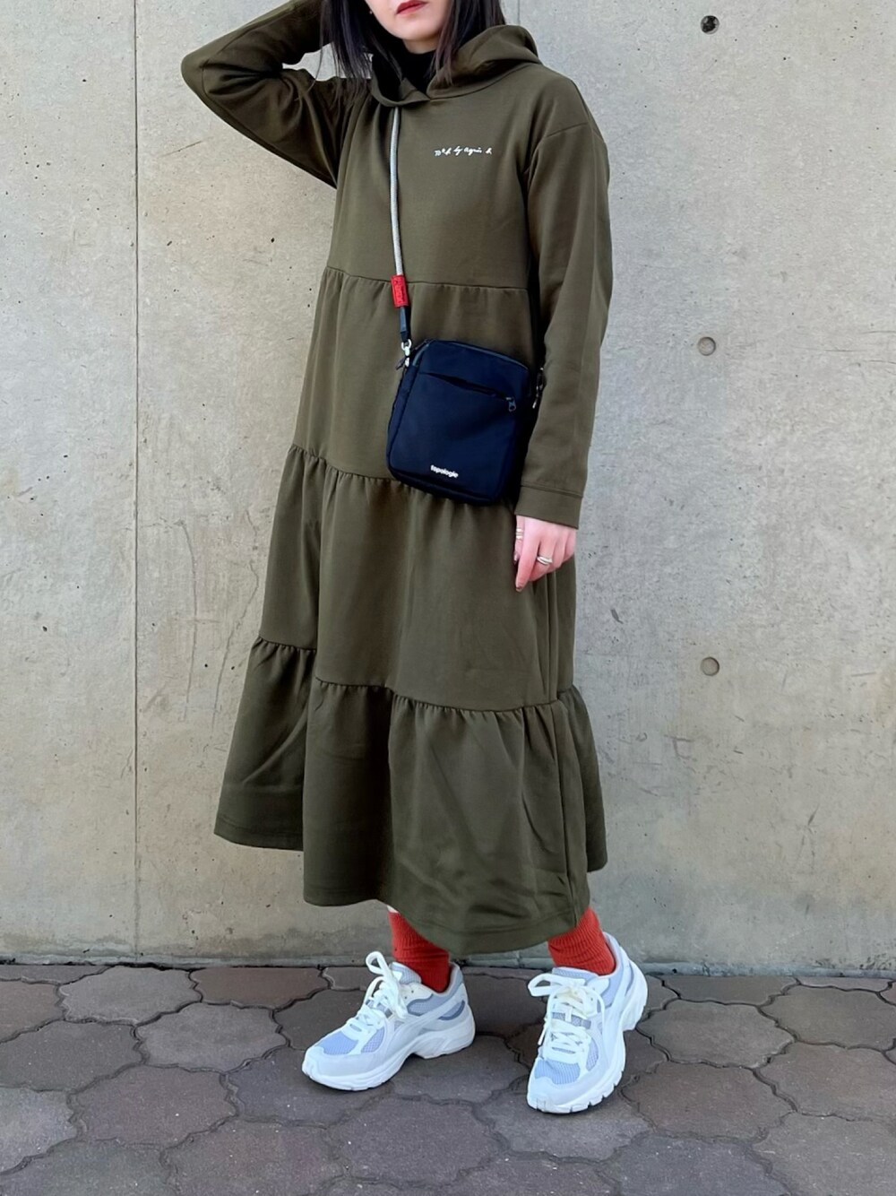 グリーン系のワンピース、ブラック系のバッグ、ブラック系のTシャツ/カットソーを着用したレディースの春コーディネートの1枚目の写真