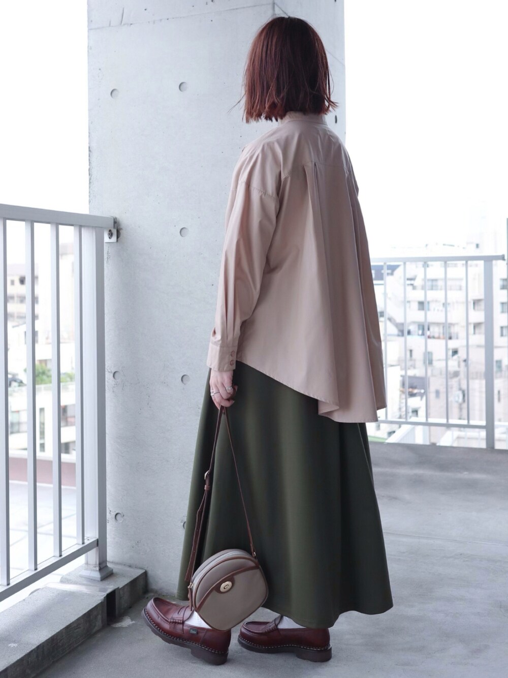 ベージュ系のシャツ/ブラウス、グリーン系のスカート、ブラウン系のローファーを着用したレディースの夏コーディネートの1枚目の写真