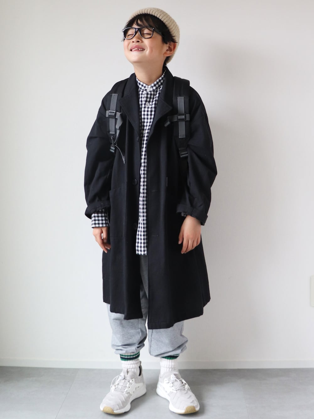 「シャツスタイル、春服みてみて、スウェット、モノトーン、ギンガムチェック、カジュアルコーデ、トレンチコート、リュック、めがね、白スニーカー、7歳、おとこのこ、ニット、ニット帽、いまどきジャケット写真」｜「GENERATORのジェネレーター ワークコート（トレンチコート、ブラック系）」を使った、KISA / SANAさん（キッズ・130cm）の春コーディネートの1枚目の写真