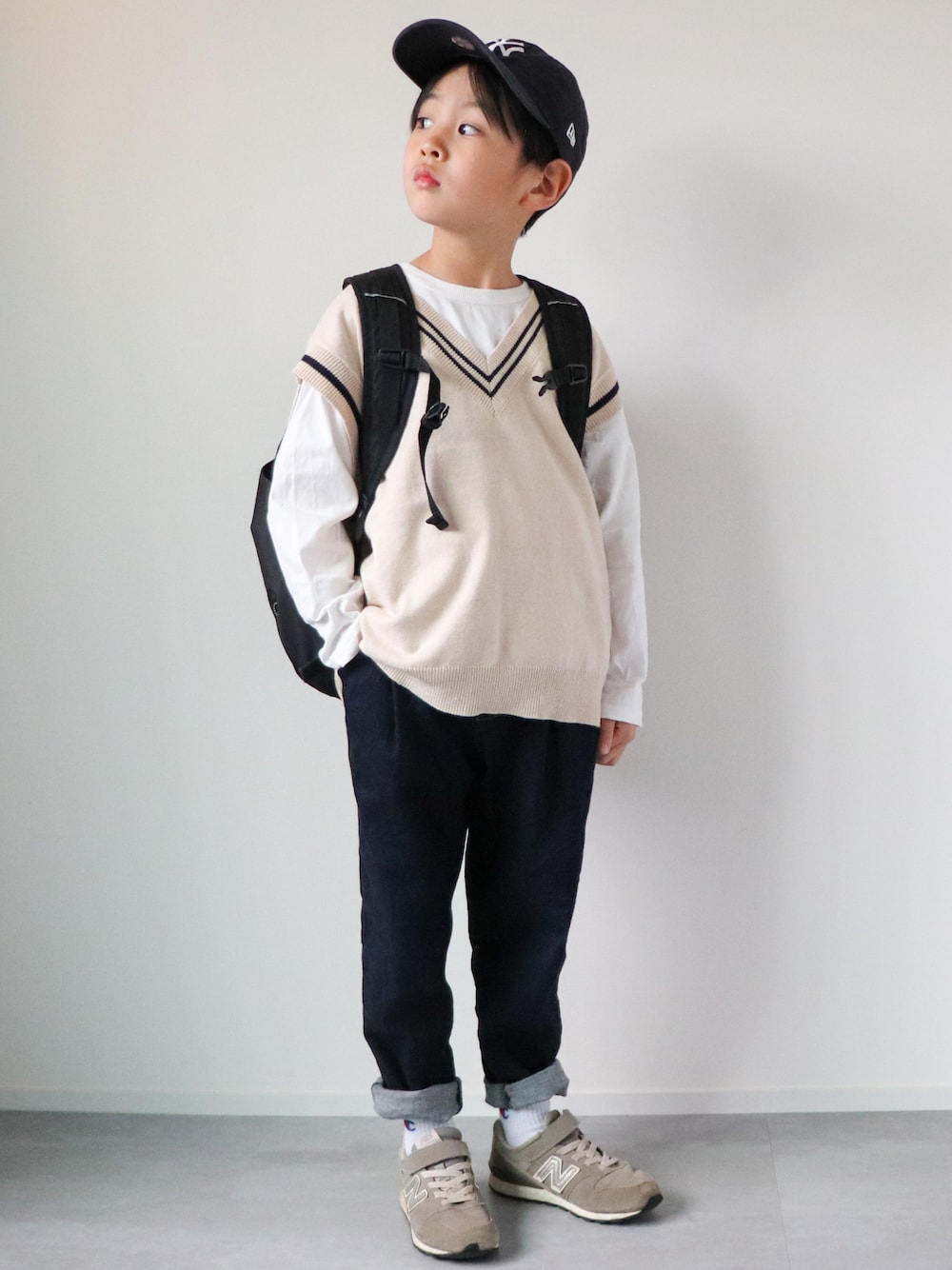 「私の推しブランド、URBAN RESEARCH DOORS、New Balance、レイヤードスタイル、春コーデ、キャップ、チルデンニット、ニットベスト、デニムパンツ、チャンピオン、リュック、黒リュック、スニーカーコーデ、5歳、おとこのこ」｜「NEW ERAのNEWERA ニューエラ KIDS 9TWENTY ニューヨーク・ヤンキース（キャップ、ブルー系）」を使った、KISA / SANAさん（キッズ・120cm）の冬コーディネートの1枚目の写真