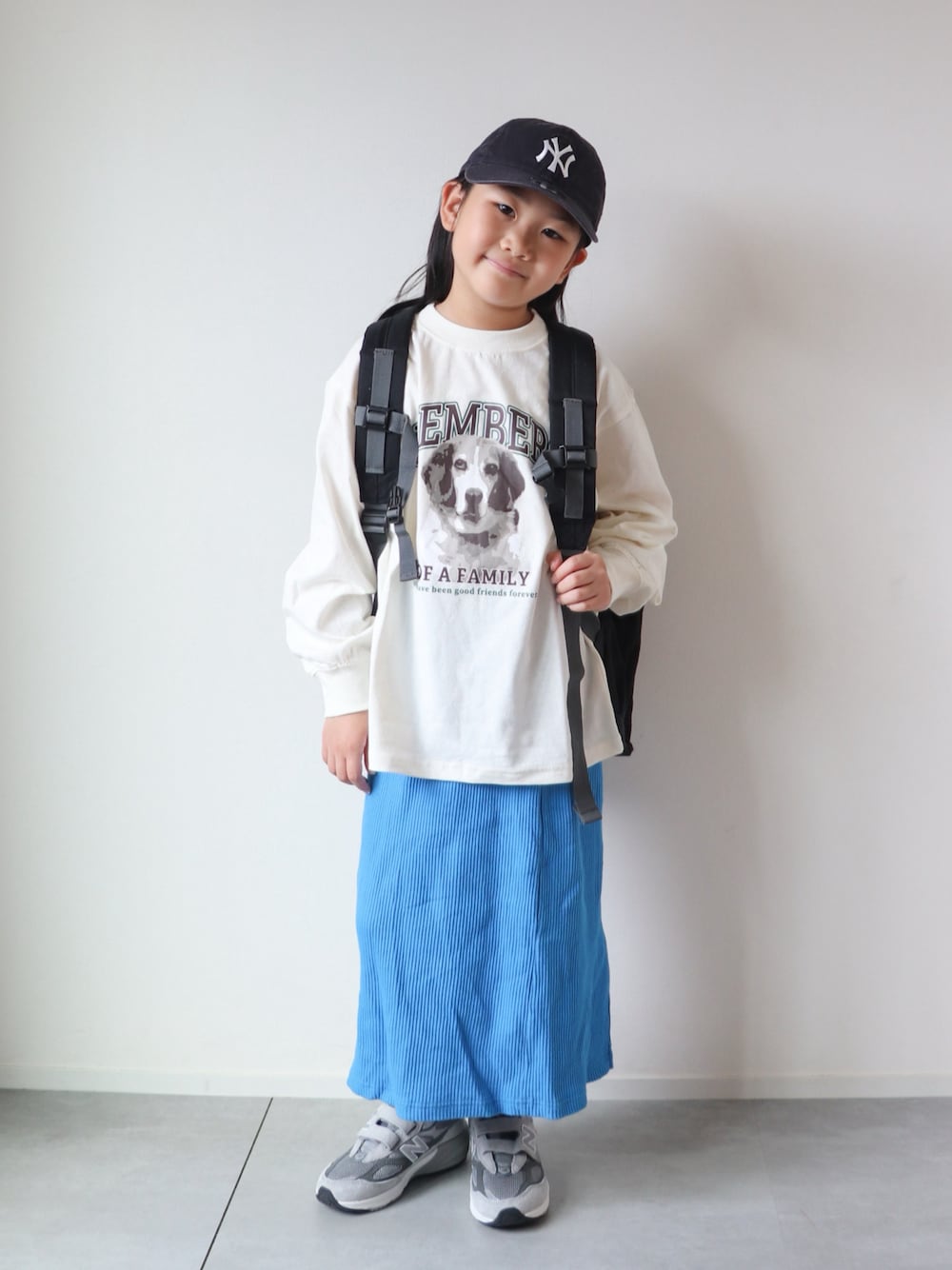 ホワイト系のTシャツ/カットソー、ブルー系のスカート、グレー系のスニーカーを着用したキッズの夏コーディネートの1枚目の写真