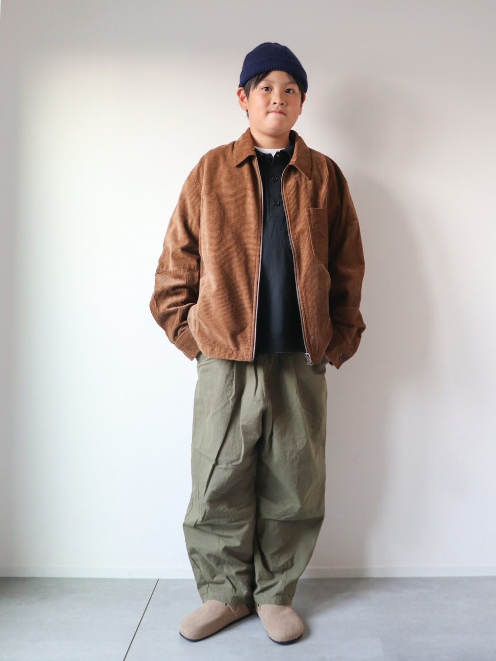 ブラック系のTシャツ/カットソー、グリーン系のカーゴパンツ、ベージュ系のスリッポンを着用したキッズの秋コーディネートの1枚目の写真