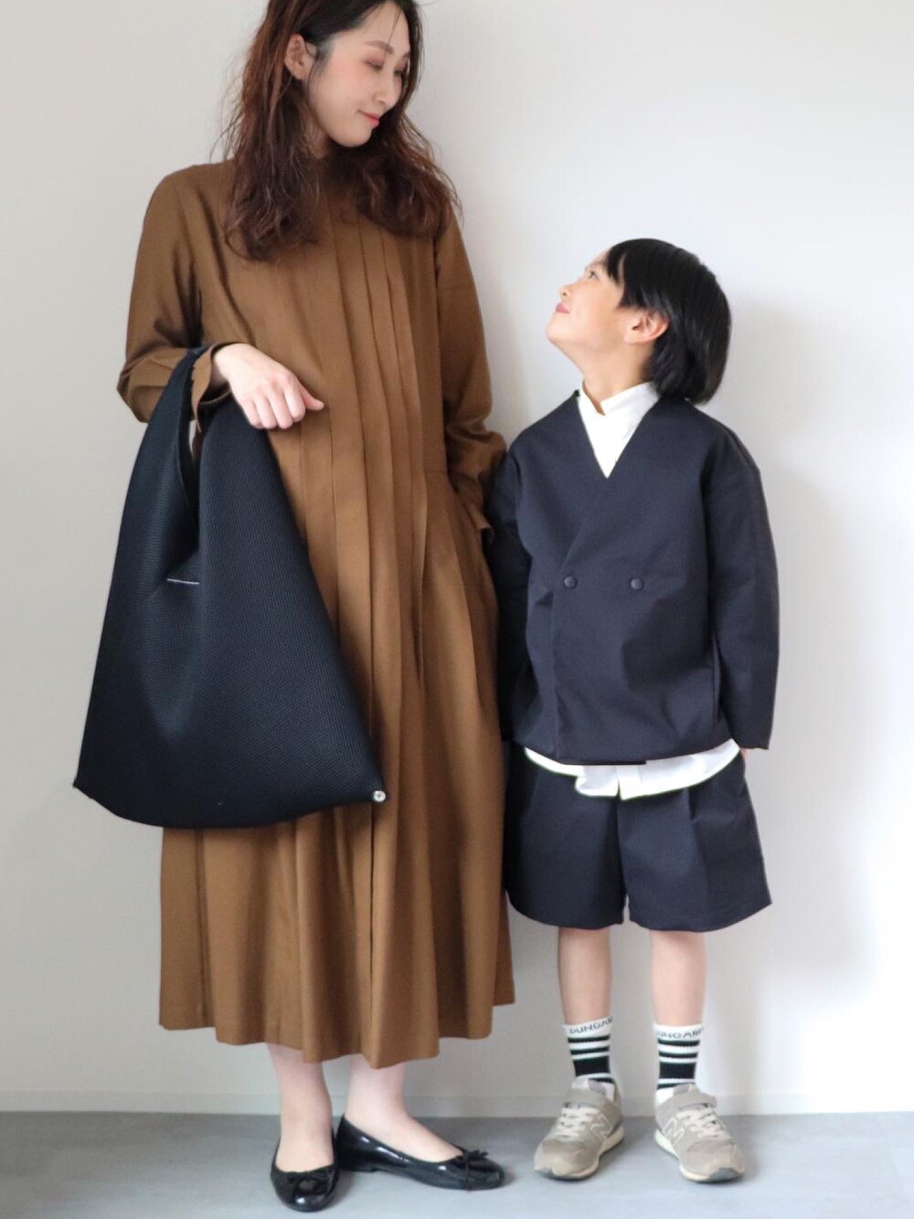 ブラック系のその他アウター、ホワイト系のシャツ/ブラウス、ブラック系のパンツを着用したキッズの春コーディネートの1枚目の写真