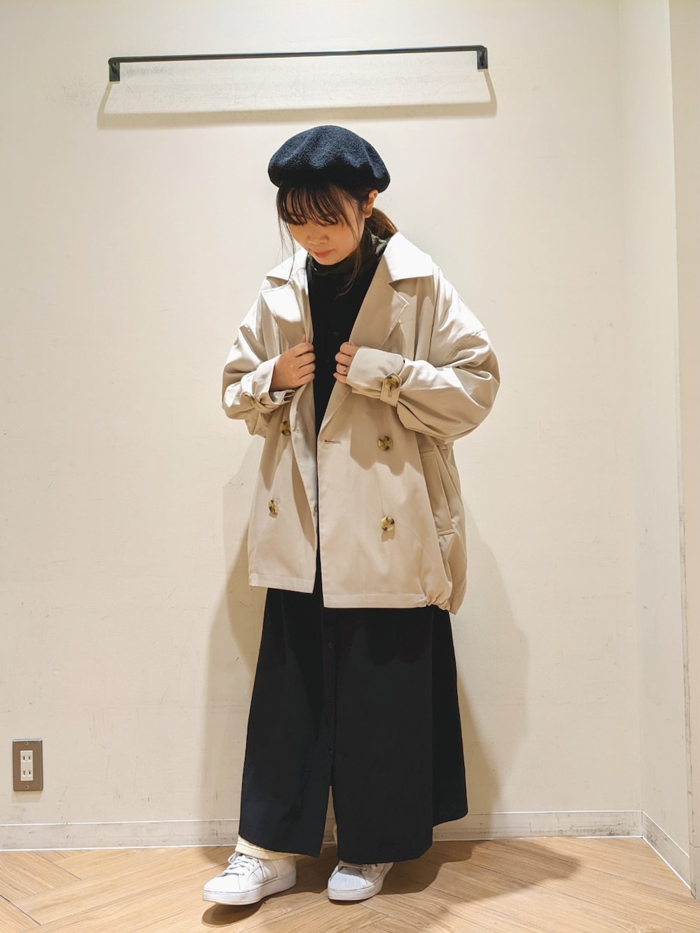 ベージュ系のトレンチコート、ブラック系のシャツワンピース、ベージュ系のその他パンツを着用したレディースの春コーディネートの1枚目の写真