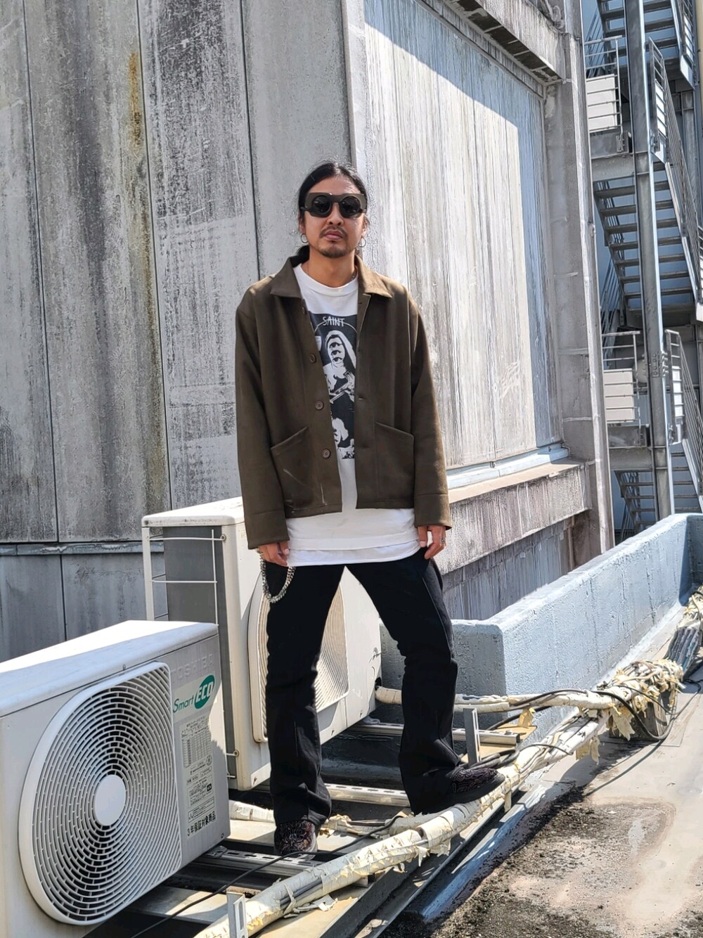 グリーン系のカバーオール、ホワイト系のTシャツ/カットソー、ブラック系のデニムパンツを着用したメンズの秋コーディネートの1枚目の写真