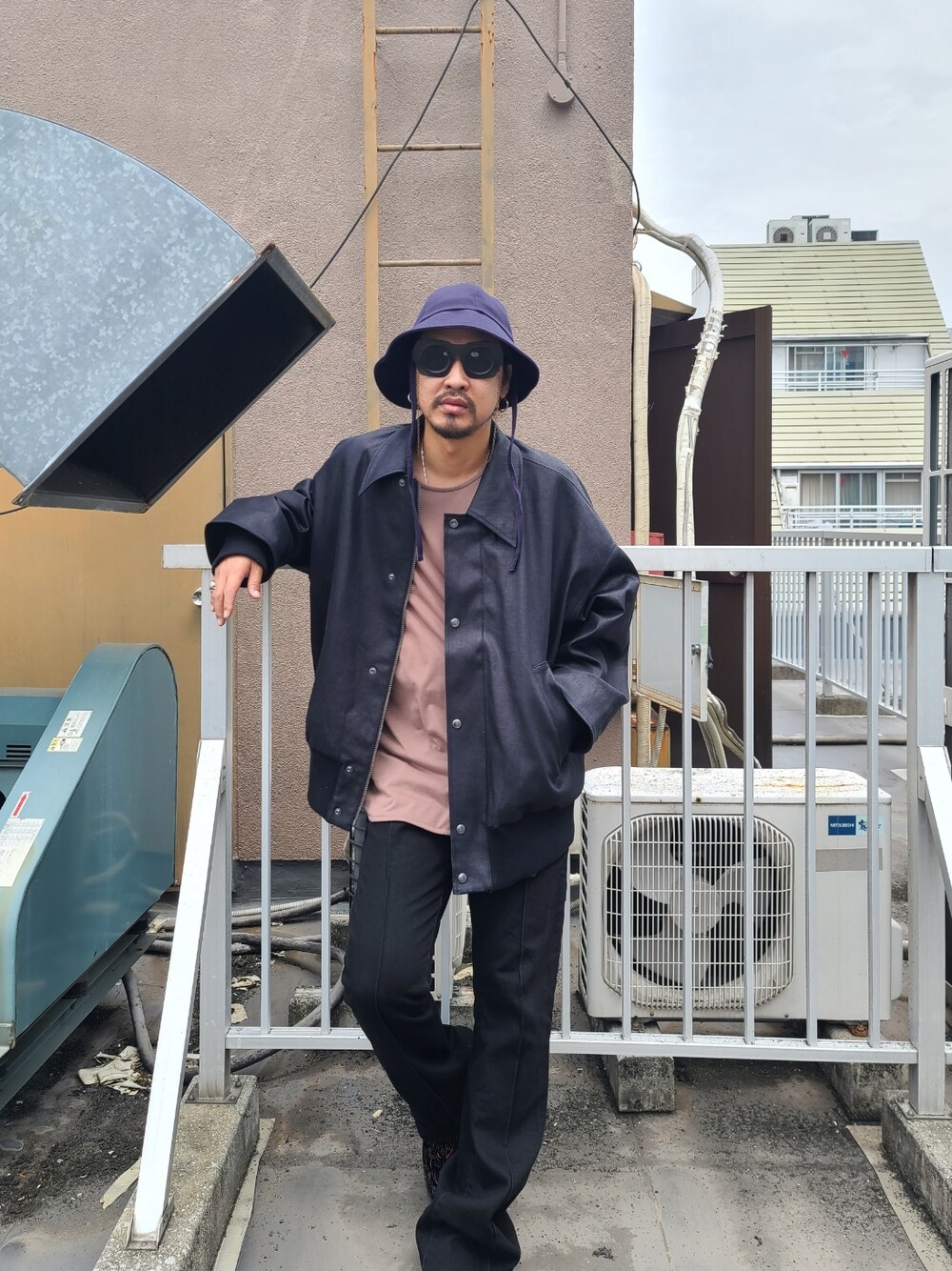 ブラック系のブルゾン、ブラウン系のTシャツ/カットソー、ブラック系のデニムパンツを着用したメンズの秋コーディネートの1枚目の写真