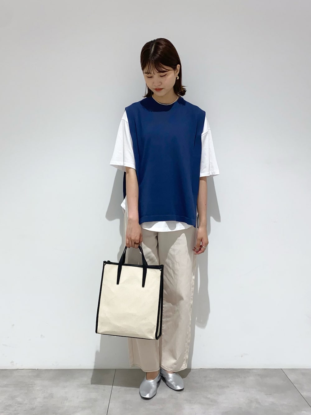 ホワイト系のデニムパンツ、ホワイト系のショルダーバッグ、ブルー系のニット/セーターを着用したレディースの夏コーディネートの1枚目の写真