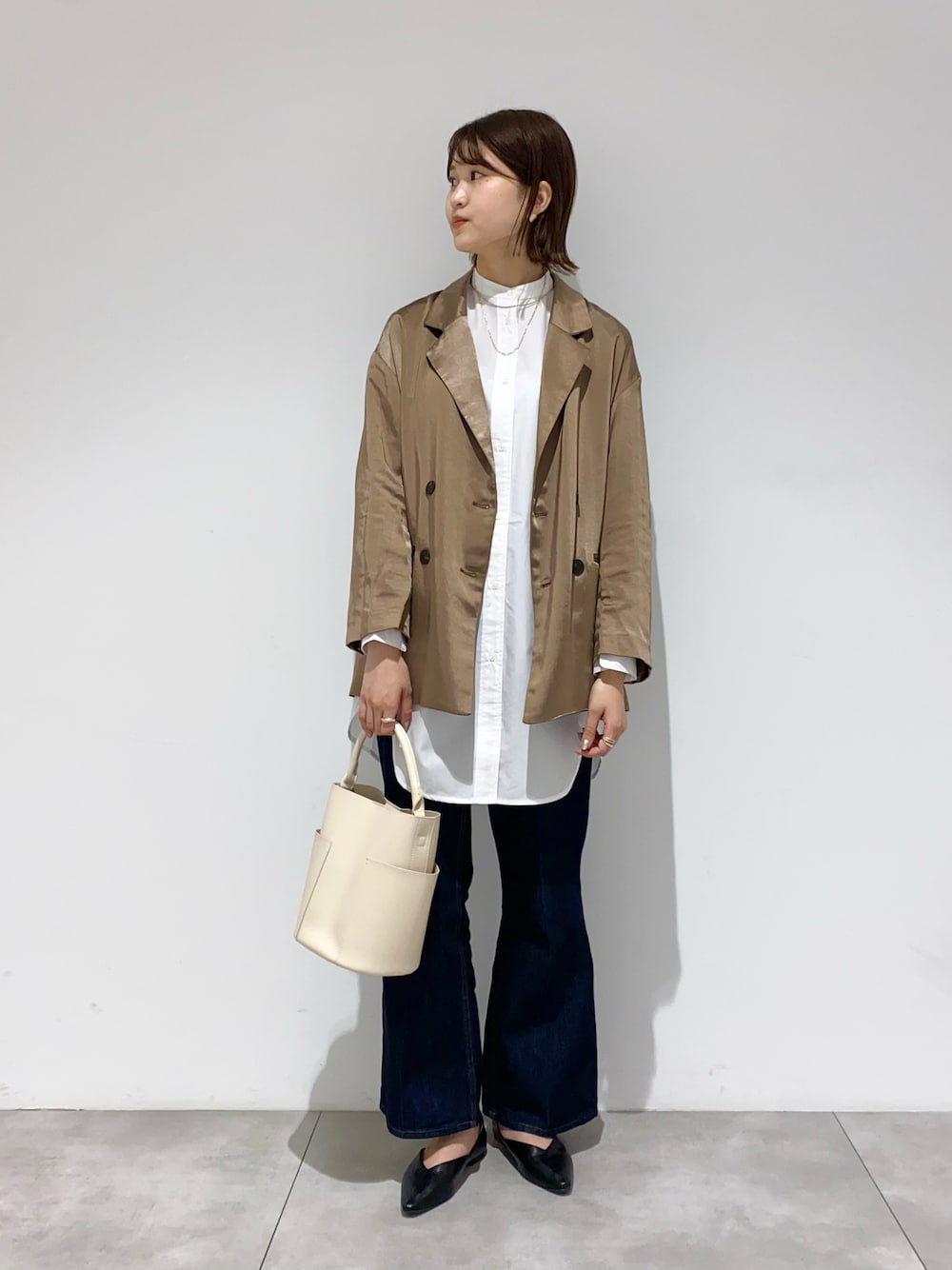 ブラウン系のその他アウター、ホワイト系のシャツ/ブラウス、ホワイト系のトートバッグを着用したレディースの秋コーディネートの1枚目の写真