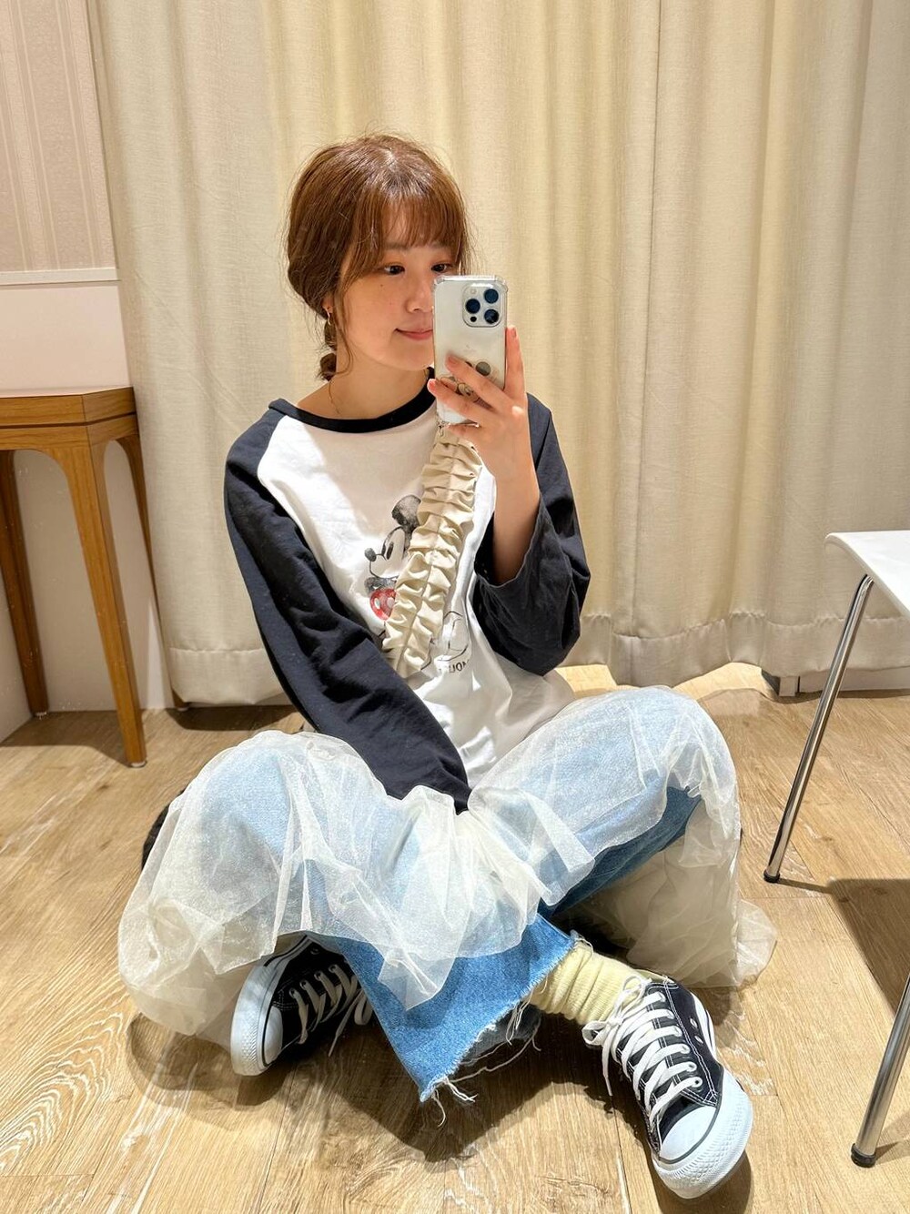 ホワイト系のスカート、ブラック系のTシャツ/カットソー、ブルー系のデニムパンツを着用したレディースの春コーディネートの1枚目の写真
