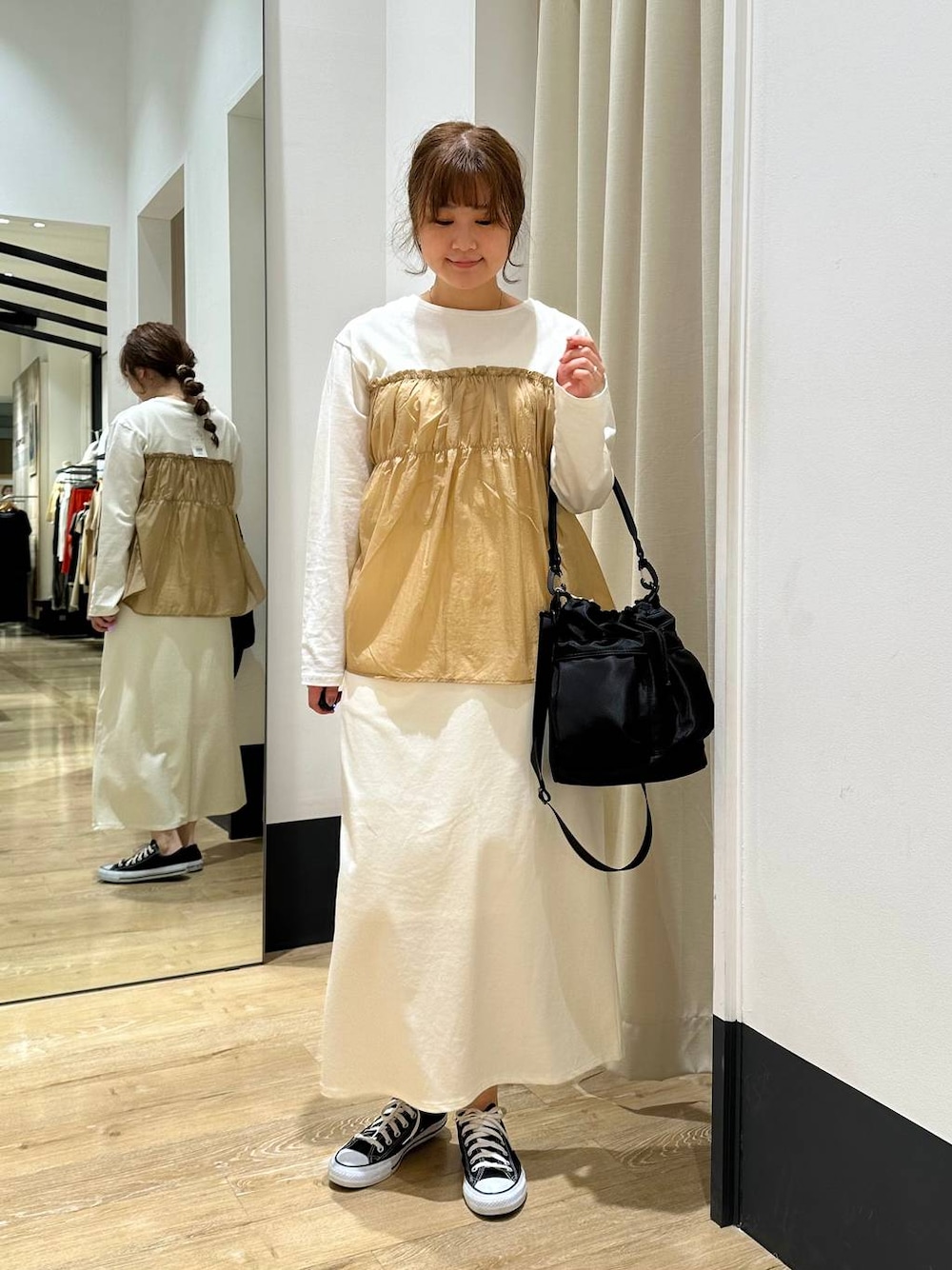 ホワイト系のスカート、ブラック系のショルダーバッグ、ベージュ系のTシャツ/カットソーを着用したレディースの春コーディネートの1枚目の写真