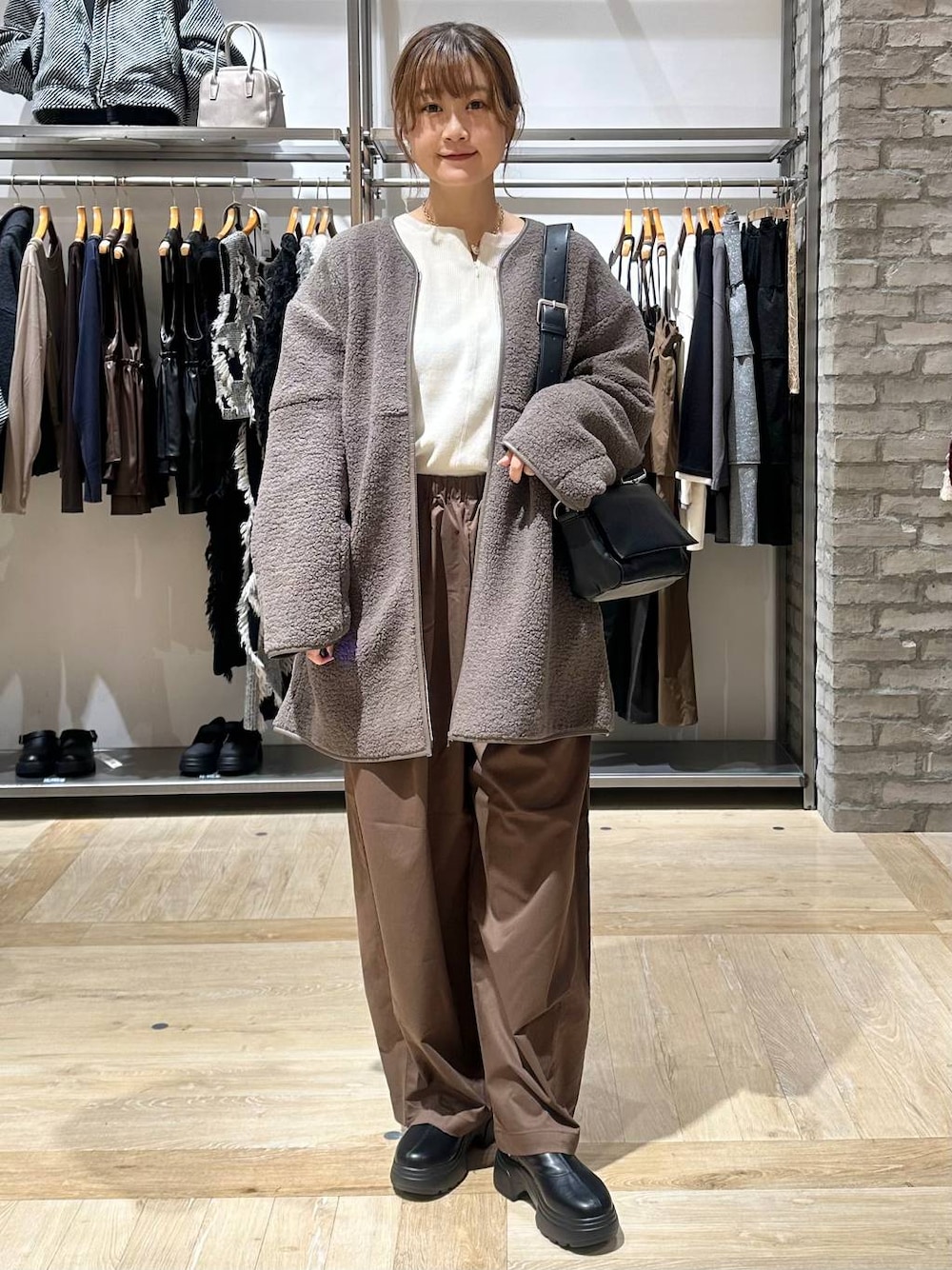 ホワイト系のニット/セーター、ブラック系のショルダーバッグ、ブラウン系のその他パンツを着用したレディースの秋コーディネートの1枚目の写真