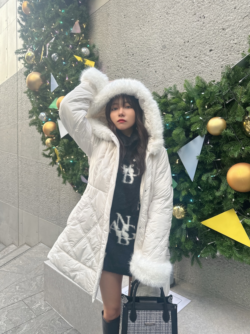 ホワイト系のダウンジャケット/コート、ブラック系のワンピース、グレー系のショルダーバッグを着用したレディースの春コーディネートの1枚目の写真