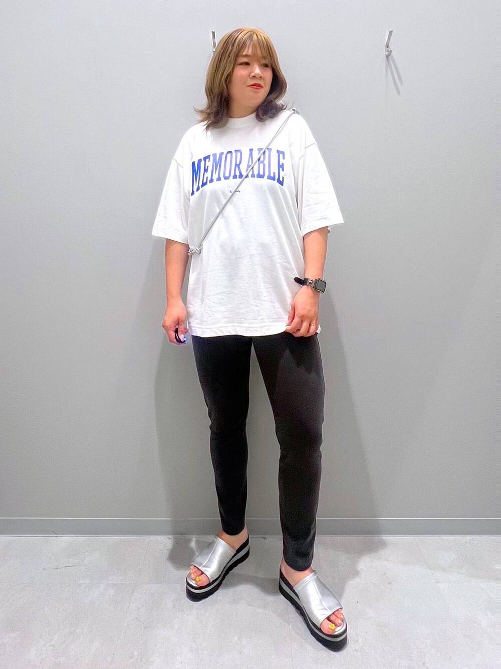 ブラック系のその他パンツ、ホワイト系のTシャツ/カットソー、グレー系のスマホグッズを着用したレディースの夏コーディネートの1枚目の写真