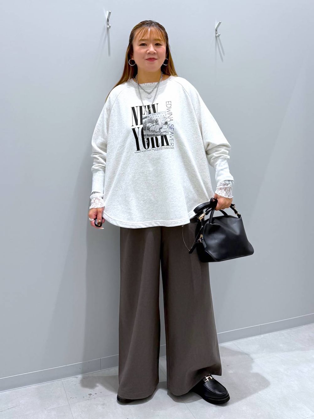 ブラック系のショルダーバッグ、ブラック系のローファー、ブラウン系のその他パンツを着用したレディースの秋コーディネートの1枚目の写真