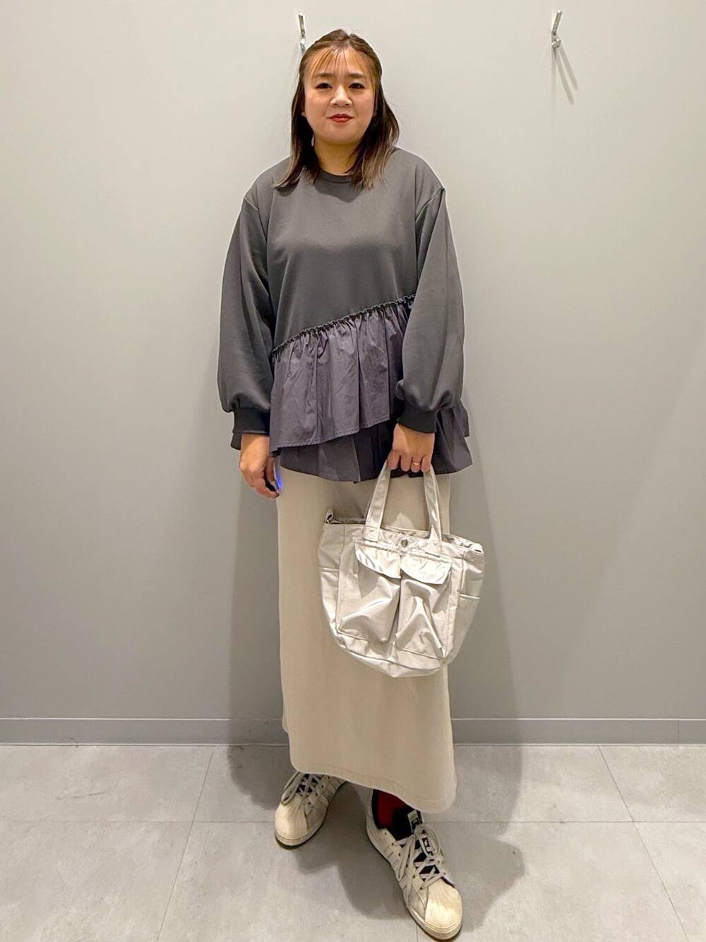 グレー系のショルダーバッグ、グレー系のTシャツ/カットソーを着用したレディースの冬コーディネートの1枚目の写真
