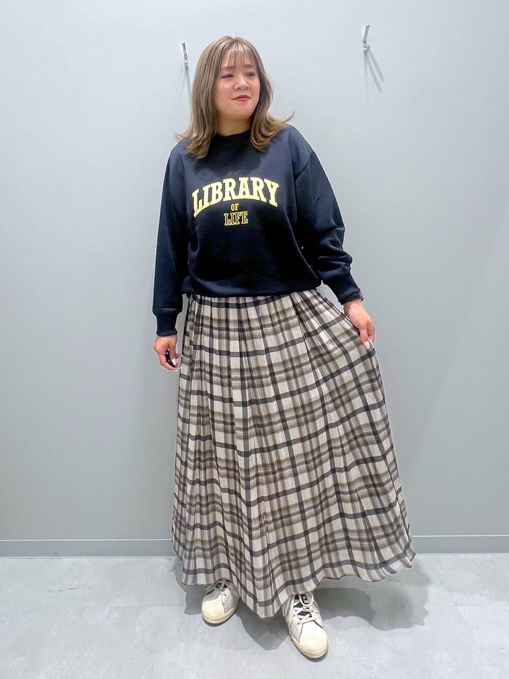 ブルー系のTシャツ/カットソー、ベージュ系のスカートを着用したレディースの秋コーディネートの1枚目の写真