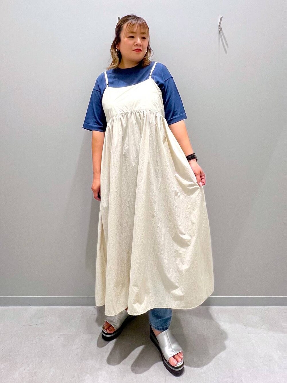 ブルー系のデニムパンツ、ホワイト系のワンピース、ブルー系のニット/セーターを着用したレディースの夏コーディネートの1枚目の写真