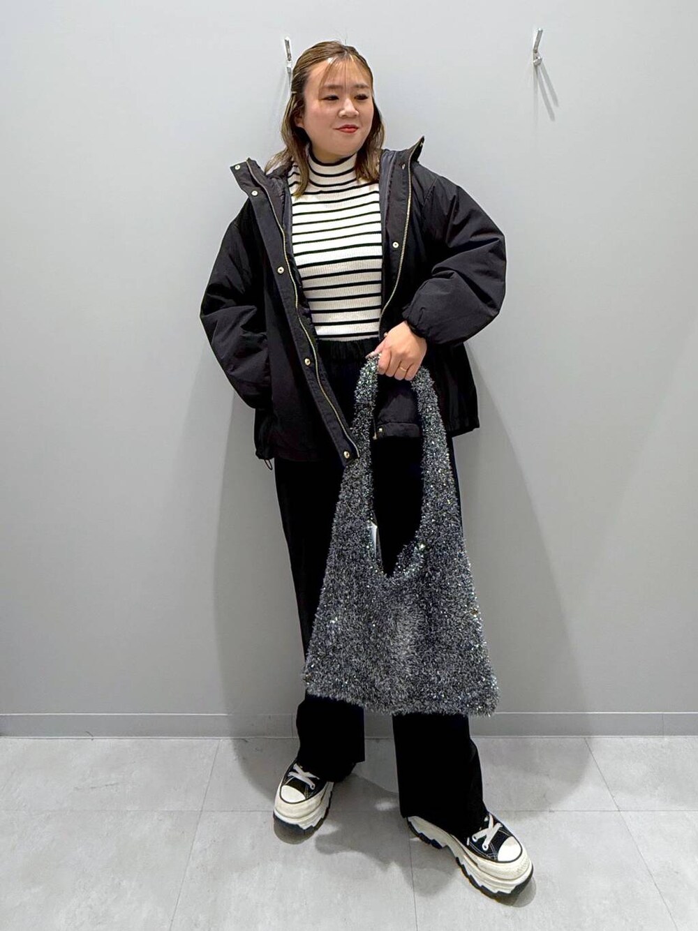 ブラック系のその他パンツ、ブラック系のブルゾン、ホワイト系のニット/セーターを着用したレディースの冬コーディネートの1枚目の写真