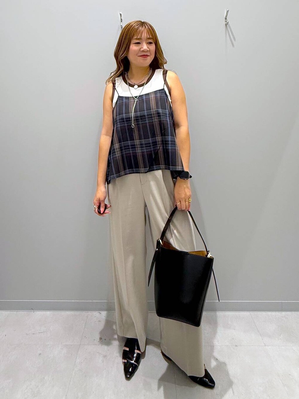 ブラック系のショルダーバッグ、ベージュ系のその他パンツ、ブラック系のパンプスを着用したレディースの夏コーディネートの1枚目の写真